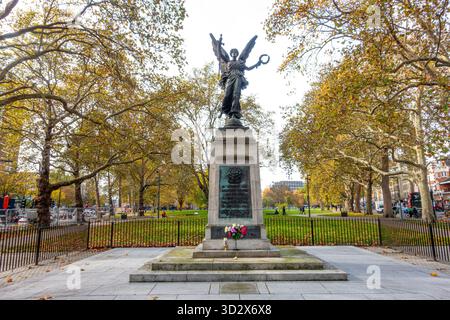 Das Kriegsdenkmal in Shepherds Bush Green in London, Großbritannien im Herbst mit goldbraunen Blättern auf den Bäumen Stockfoto