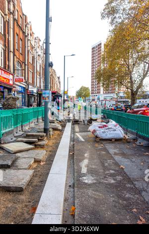 An einem Straßenbelag in Shepherds Hush in London, Großbritannien, werden Reparatur- und Verbesserungsarbeiten durchgeführt, einschließlich der Installation einer neuen Bordsteinkante. Stockfoto