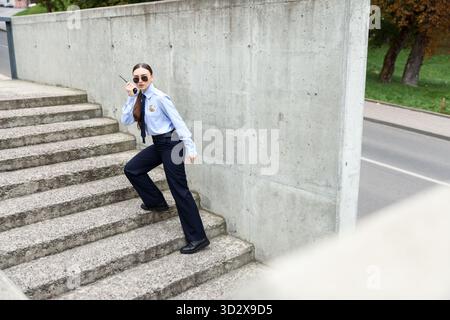 Polizist mit Funkgerät auf Stufen draußen. Leerzeichen für Text Stockfoto