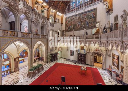 Atemberaubender Blick von oben auf die große Halle in Schloss de Haar (Kasteel de Haar), mit mehreren Ebenen neogotischer Bögen, Statuen und einem großen Wandteppich Stockfoto