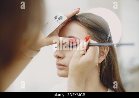 Schöne junge Frau, die Make-up-Schönheitsbürste aufträgt Stockfoto