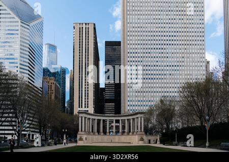 Chicago, USA - 15. April 2025: Blick auf Chicago mit dem Wrigley Square Peristyle Monument, umgeben von modernen Wolkenkratzern und üppig grünem Park Stockfoto
