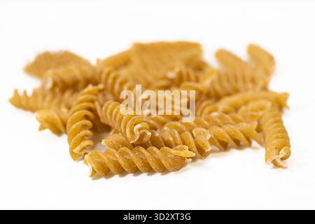 Getrocknete Vollkornnudeln auf weißem Hintergrund mit Kopierraum – gesundes Bio-Lebensmittel- und Kohlenhydratzutaten-Konzept Stockfoto