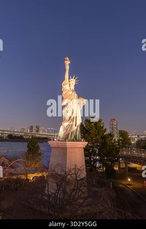 Tokio, Japan - 14. März 2025: Erleuchtete Odaiba Freiheitsstatue eine Nachbildung der Originalstatue in New York in der Nähe der Regenbogenbrücke mit Blick auf die Bucht von Tokio, Japan Stockfoto