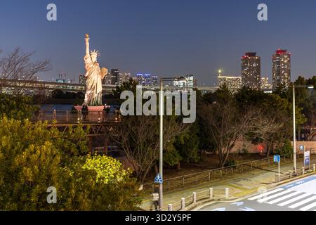 Tokio, Japan - 14. März 2025: Erleuchtete Odaiba Freiheitsstatue eine Nachbildung der Originalstatue in New York in der Nähe der Regenbogenbrücke mit Blick auf die Bucht von Tokio, Japan Stockfoto