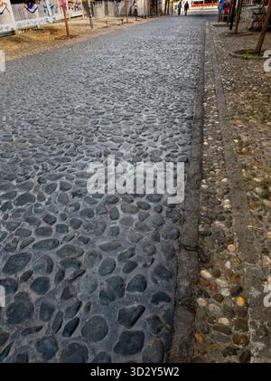 Nahaufnahme des Kopfsteinpflasterpflasters in der Skadarska-Straße in Belgrad, Serbien, mit glatten dunklen Steinen, die von helleren Kies und schmalen S begrenzt werden Stockfoto