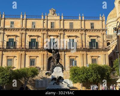Rathaus von Noto und Kriegsdenkmal auf der Piazza del Municipio. Noto, Italien - 10. Oktober 2025 Stockfoto