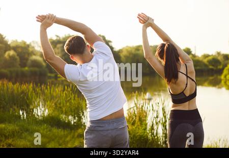 Sporttraining und gesundes Training des Active Fit Paares Stretching Körper in Seitenbeugen, Rückansicht Stockfoto