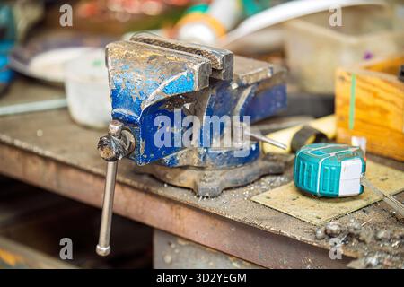 Ein blaues Werkzeug, mit dem Dinge an Ort und Stelle gehalten werden. Es ist schmutzig und hat viel Rost Stockfoto