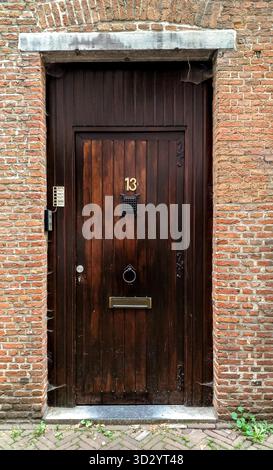 Antwerpen, Belgien - 23. August 2018 - rustikale Holztür mit Nummer 13 in Backsteinmauern. Stockfoto