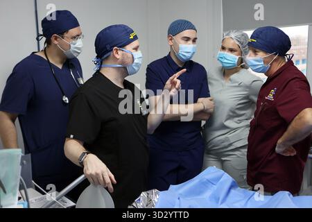 Nicht exklusiv: Medizinisches Personal spricht in einem Operationssaal, in dem plastische Chirurgen aus Kanada, den Vereinigten Staaten und der Ukraine eine der Rekonstruktionen durchführen Stockfoto