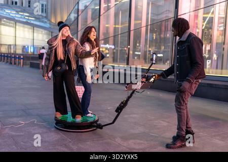 London, Großbritannien, 23. November 2025, zwei glückliche Frauen posierten für ein Zeitlupenvideo auf einer 360-Grad-Fotoplattform. Stockfoto
