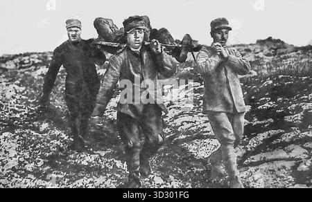 Ab Le Miroir, 24. September 1916. Während des Ersten Weltkriegs transportieren italienische Bahrträger einen verwundeten Kameraden über exponiertes Gelände an der Carso-Front. Mit Gräben, die in felsigem Boden nicht zu graben waren, riskierten Mediziner ihr Leben, um die Verletzten unter feindlichem Feuer zu retten. Dieses eindrucksvolle Bild spiegelt den Mut und die Ausdauer italienischer Soldaten wider, die sich den einzigartigen Schwierigkeiten des Bergkriegs in den Alpen stellen. Stockfoto