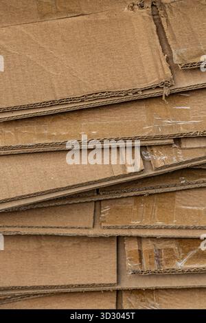 Eine Ansicht von oben nach unten auf einen großen, unordentlichen Stapel flacher Wellpappkartons, die für das Recycling bereit sind. Stockfoto