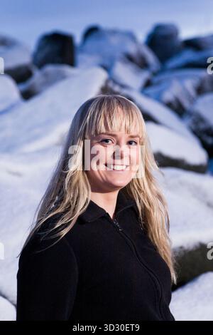 Junge Frau lächelt im Winter. Grotta (Grótta), Reykjavik, Island. Dämmerung. Stockfoto