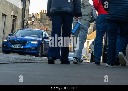 Fußgänger, die auf dem Gehweg mit Autos in unmittelbarer Nähe auf der Edinburgh Road, South Queensferry, Edinburgh, Großbritannien laufen. Nahaufnahme, Bodenfoto. Stockfoto