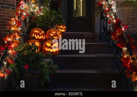 Halloween Kürbisse auf Queens NY Stoop in der Nacht Stockfoto