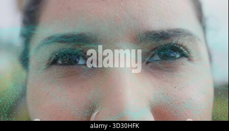 Zeigt das Gesicht einer indischen Frau, die im Labor AR-Scan durchläuft, mit metallischem Nasenring und türkisfarbenem Netz Stockfoto