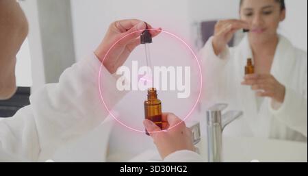 Mit einer Pipettenpipettenfrau in weißem Bademantel Serum in eine braune Flasche am Waschbecken im Badezimmer umfüllen Stockfoto