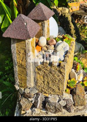 Miniatur-Steinburg im Garten. Märchenhafter Steingarten mit Pyramiden. Gartendekor aus Stein und Sukkulenten. Stockfoto