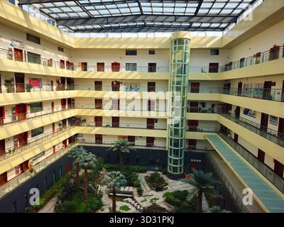 Modernes Büro-Atrium mit Glasaufzug und Innengarten in China Stockfoto
