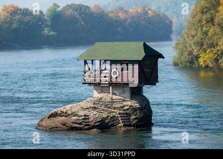 Die berühmte Hütte auf einem Felsen im Fluss Drina bei Bajina Basta in Serbien mit Herbstfarben um sie herum. Oktober 2025. Stockfoto