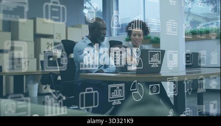 Zusammenarbeit mit zwei Experten, die Daten auf Laptops im Bürospeicher analysieren, mit variablen Diagrammen Stockfoto