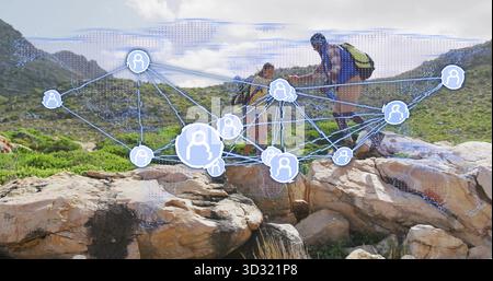 Navigation zweier Wanderer durch felsige Ausläufer auf dem Bergkampfpfad mit digitalem Netzwerk Stockfoto