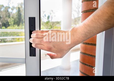 Hand eines Mannes, der im Winter die Tür schließt Stockfoto