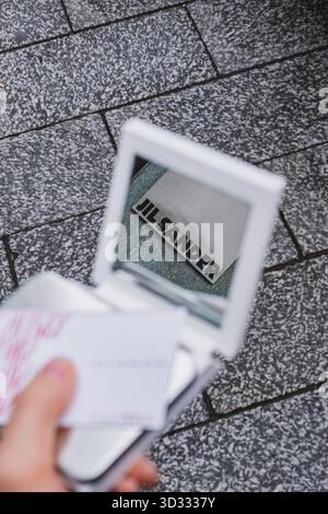 Jil Sander Logo der Modemarke spiegelt sich in einem Taschenspiegel wider Stockfoto