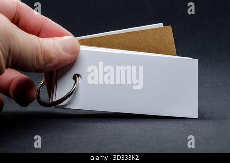 Weißes Notizblock in Handform mit anpassbarem Platz für Text auf schwarzem Umschlaghintergrund Stockfoto