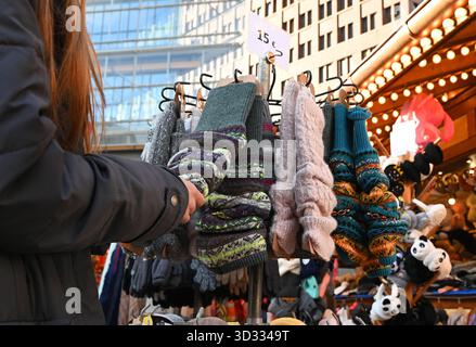 Berlin, Deutschland. November 2025. Eine Frau steht an einem Weihnachtsmarkt, der Wintersocken in Berlin verkauft. Quelle: ELISA Schu/dpa/Alamy Live News Stockfoto