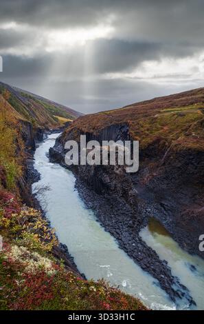 Der malerische Studlagil Canyon im Herbst ist eine Schlucht in Jokuldalur im Osten Islands. Berühmte Basalt-Felsformationen und der Jokla River fließt durch ihn. Stockfoto