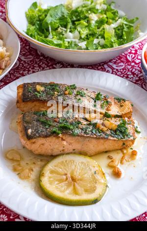 Gebackener Lachs mit Zitronensauce und Salatschüssel Stockfoto
