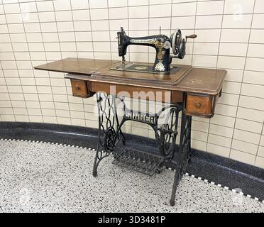 Den Helder, Niederlande. Dezember 2024. Eine alte Sängerin Nähmaschine auf einem Hintergrund aus Granitboden und Vintage Fliesen. Stockfoto