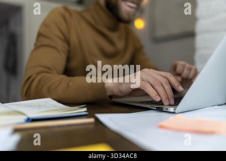 Nicht erkennbarer Mann freiberuflich in Brille, der zu Hause oder im Café mit Laptop arbeitet Stockfoto