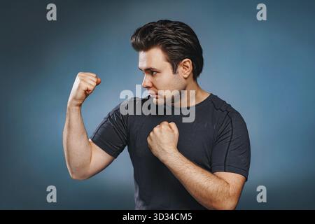 Junger brünetter Kämpfer auf blauem Hintergrund Stockfoto