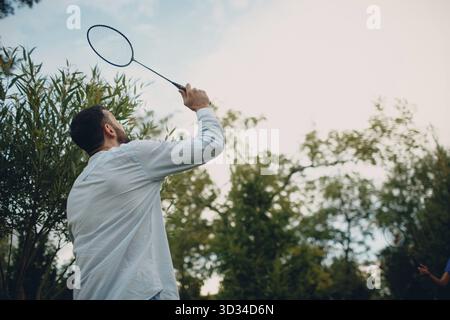 Junges erwachsenes Paar spielt Badminton im Park Stockfoto