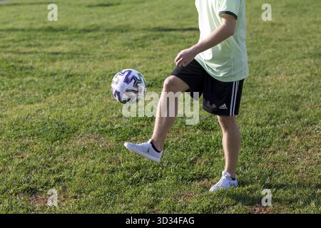 Football Freestyle. Junger Mann trainiert mit Fußball. Der Spieler trainiert die grundlegenden Tricks mit dem Ball Stockfoto