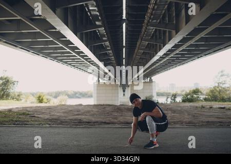 Junger sportlicher Kerl, der Parkour an der Stadtstraße macht Stockfoto