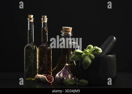 Infundiert Olivenöl, Kräutern und Gewürzen auf dunklem Stein Hintergrund Stockfoto