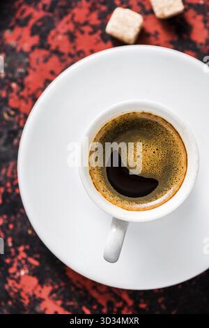 Starker Espresso mit Schaum, Zuckerwürfel auf rustikalem Holztablett Stockfoto