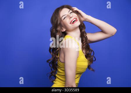 Porträt eines lächelnden brünetten Mädchens mit langen welligen Haaren. Isolieren Stockfoto
