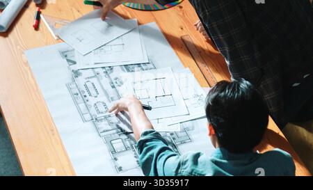 Nahaufnahme der Ingenieure, die den Projektmanager nach dem Plan befragen. Gruppe von Architekten, die ein Brainstorming durchführen und dabei den Plan erklären Stockfoto