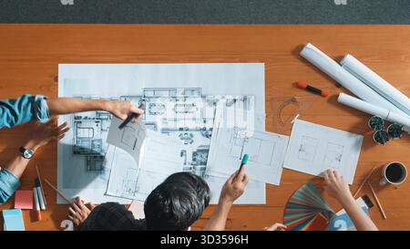 Gruppe von Personen, die sich beim Brainstorming eine Idee anschauen. Draufsicht auf die Suche und Planung des Hausbaus durch das Ingenieurteam mithilfe von Blueprint Stockfoto