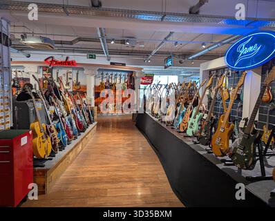 Köln, Deutschland - 26. September 2025: E-Gitarren werden in einem Musikgeschäft zum Verkauf angeboten, in dem verschiedene Modelle und Farben unter hellem LIG präsentiert werden Stockfoto