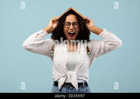 Junge Schwarze Frau drückt Frustration aus, während sie im Blue Studio studiert Stockfoto