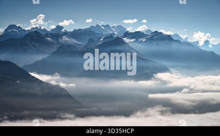 Berge über Wolken in den Schweizer Alpen mit schneebedeckten Gipfeln Stockfoto