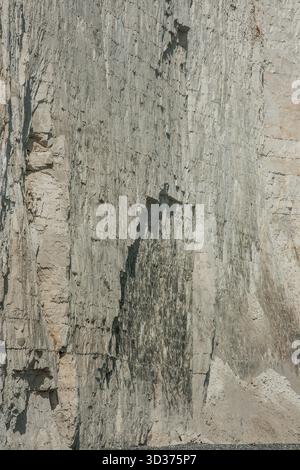 Weiße Kreideklippe in der Nähe von Beach Head oder Eastbourne. Nahaufnahme der steilen Klippe mit Schichten von Sedimentgestein, Rissen und Erosion Stockfoto