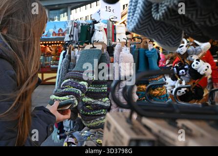 Berlin, Deutschland. November 2025. Eine Frau steht an einem Weihnachtsmarkt, der Wintersocken in Berlin verkauft. Quelle: ELISA Schu/dpa/Alamy Live News Stockfoto